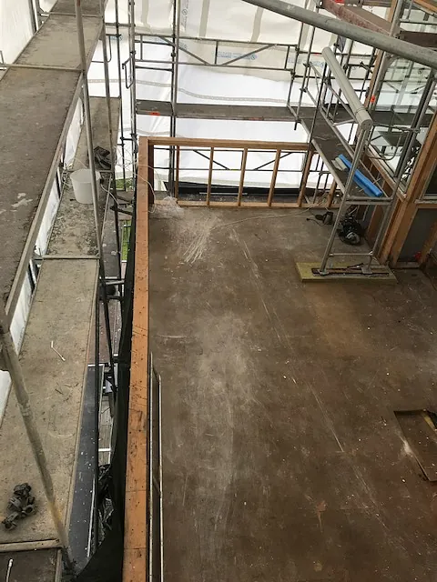 Oversikt over byggeplass med stillas og åpen gulvflate.