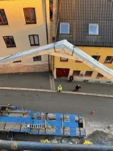 Heving av takseksjon med kran, sett fra høyden over en gate.