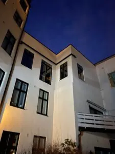 Ferdig renovert bakhagefasade opplyst i kveldslys.